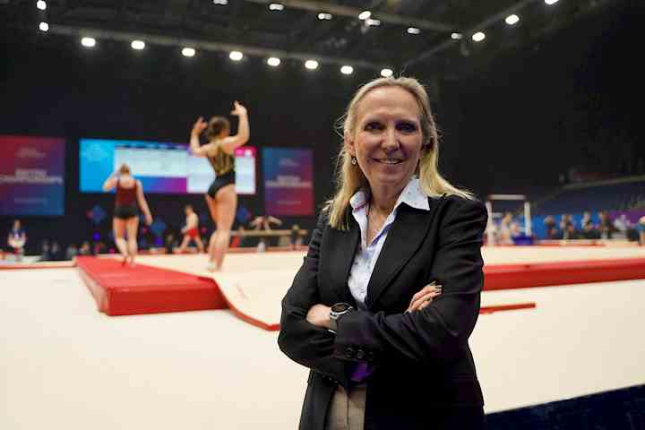 Clare Briegal stood in front of gymnasts performing