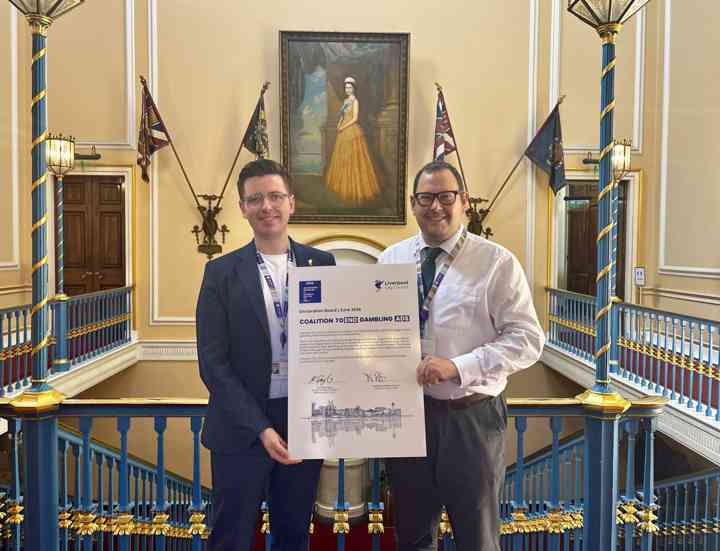 Harry Doyle and Matt Ashton stood holding a placard in the Town Hall