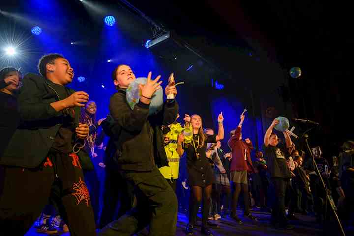 Large group of children on stage mid performance