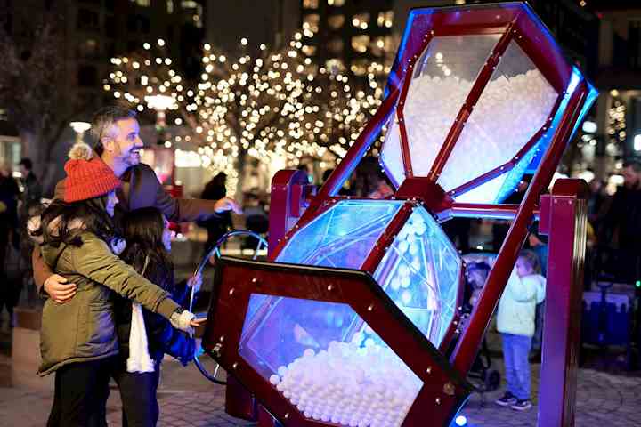 A giant egg timer being turned by a couple and a child