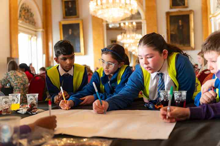 Children from Liverpool Schools' Parliament writing on a large piece of paper