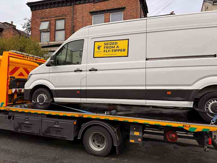 A van on the back of a pick-up, with 'seized from a fly-tipper' written on the side.