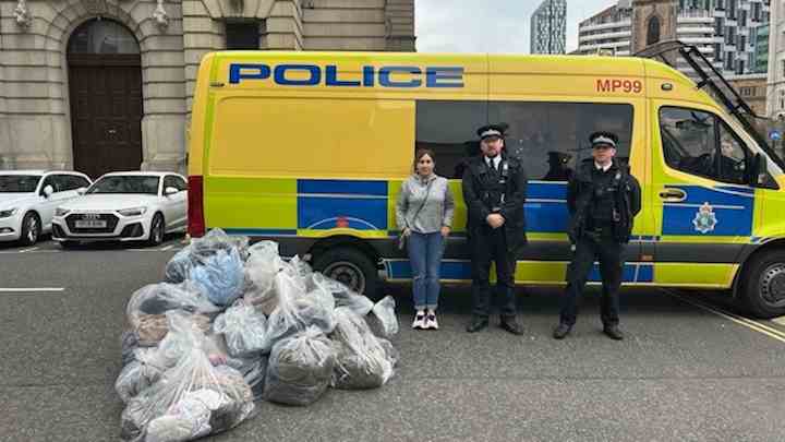 A police van with bags of counterfeit clothing in front