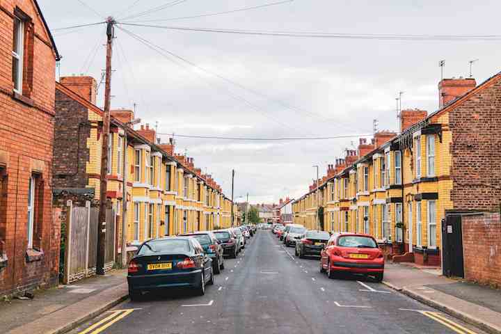 Liverpool street of houses with cars parked on the road.