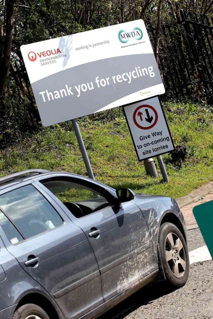 A car driving past a 'Thank you for recycling' sign