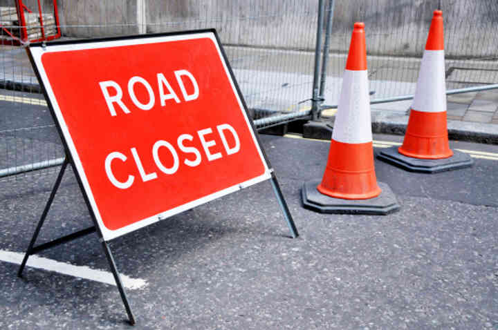 A road closed signed with cones